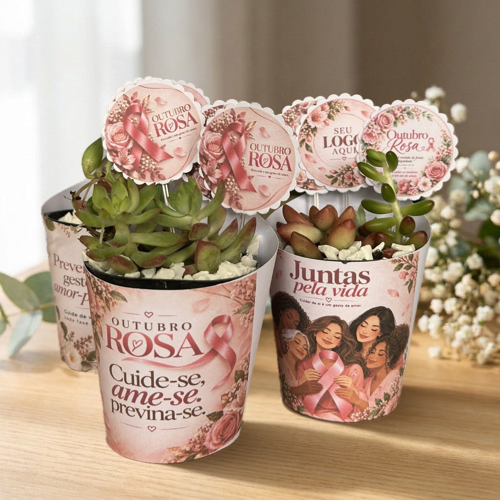 Foto real de lembrancinhas de Outubro Rosa: suculenta com rótulo rosa, tag com o logo da empresa e pedrinhas brancas, sobre mesa de madeira